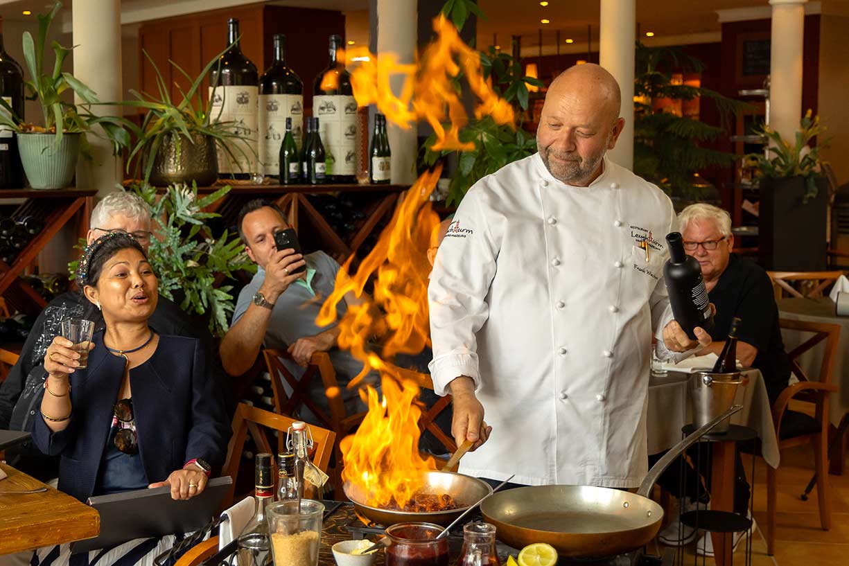 Leuchtturm_Harburg_Private_Dining Der Koch Frank Wiechern bereitet am Tisch ein flambiertes Gericht zu
